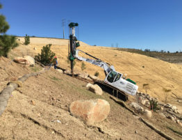 Western Foundations's rig drills into a steep hill for stair foundations using a small limited access drill.